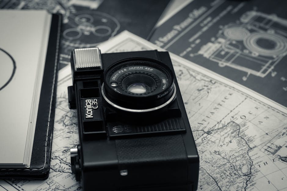 High angle of classic vintage black photo camera placed on map for voyage