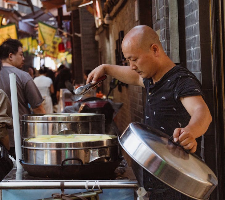 A street vendor preparing traditional Chinese food in a bustling outdoor market.