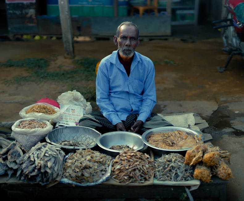 Portrait of a Bangladeshi man selling dried fish in a village market, showcasing local culture.
